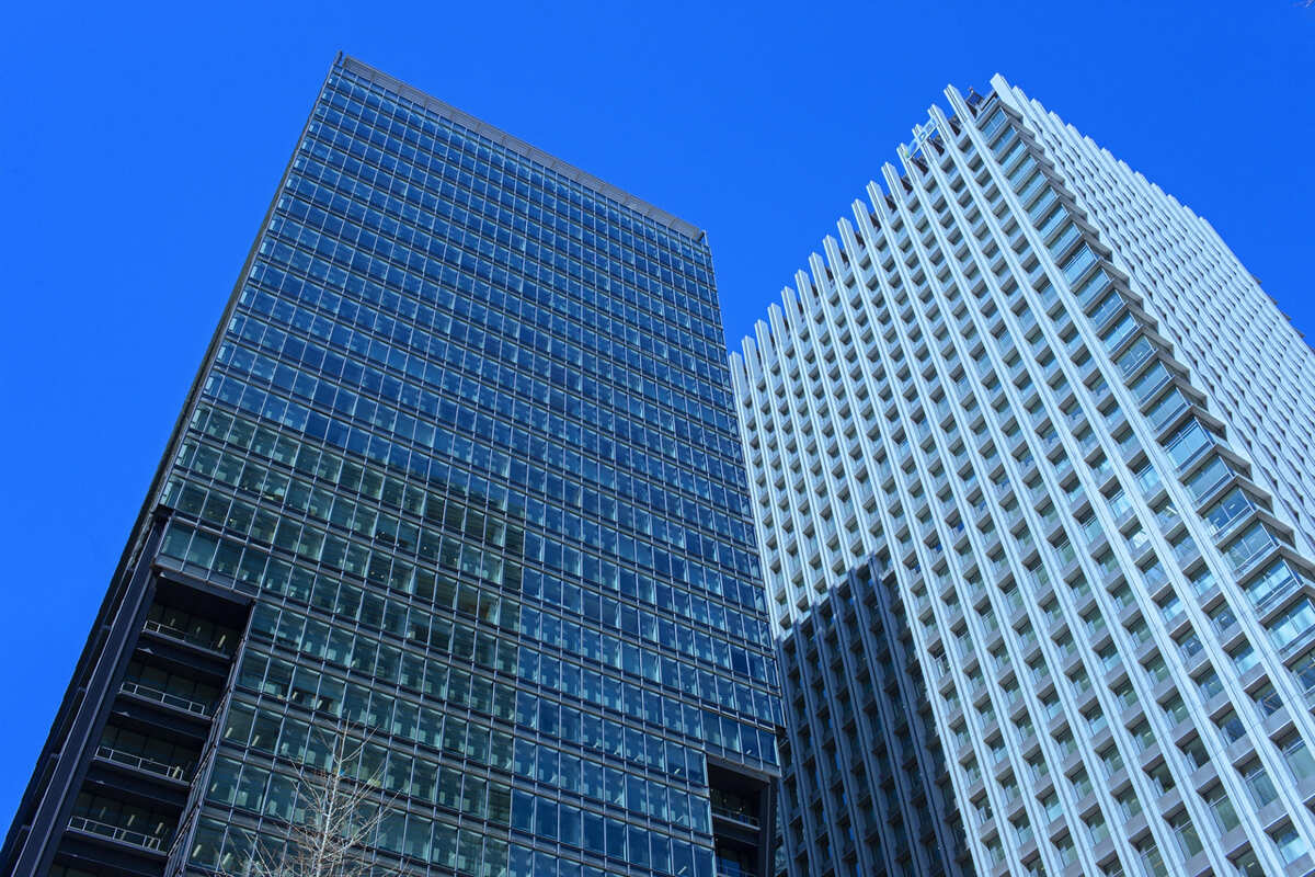 METSバーチャルオフィス解約手続きの注意点まとめページのイメージ画像。東京都心の高層ビル群が青空に映える風景で、ビジネス拠点としての利便性を象徴。解約時の手続きや注意点を解説する内容を示す。