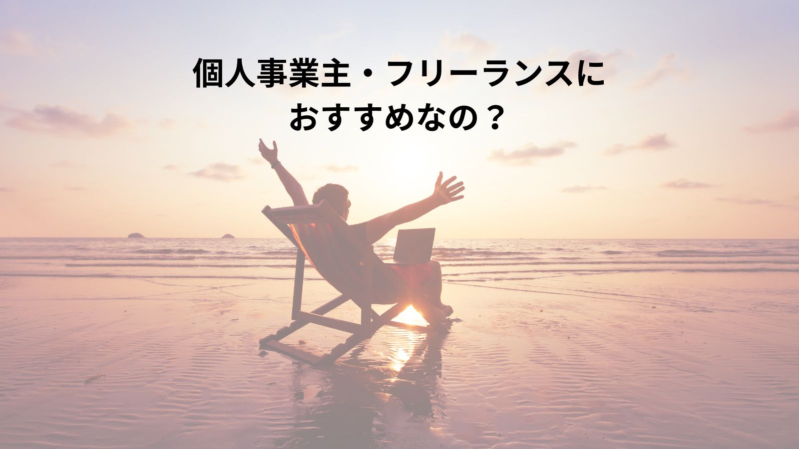 バーチャルオフィスTHE HUBは個人事業主やフリーランスにおすすめか? 夕焼けのビーチでリラックスする男性の後ろ姿。パソコンと飲み物が近くに置かれている。